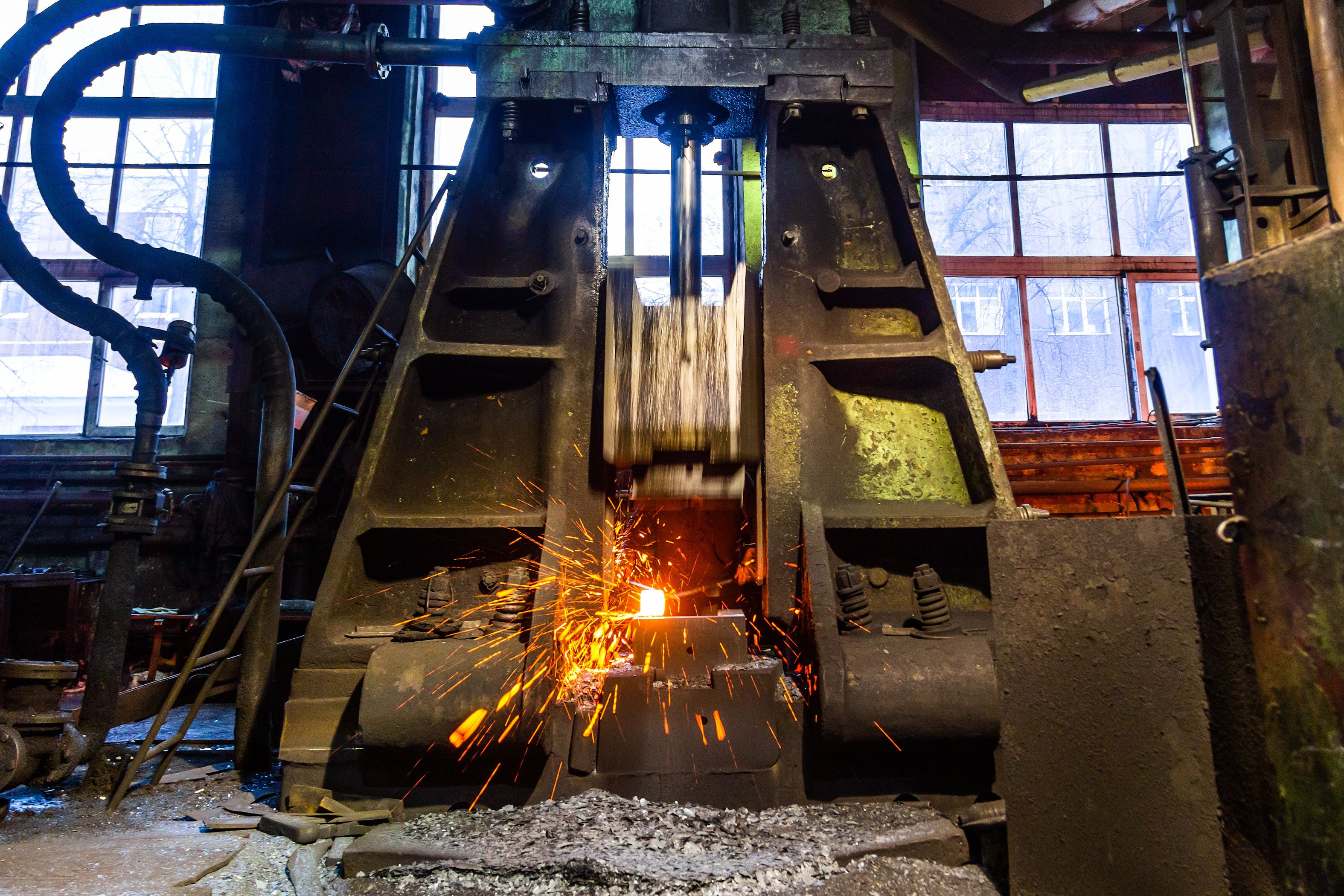 Large forging hammer pressing a piece of metal