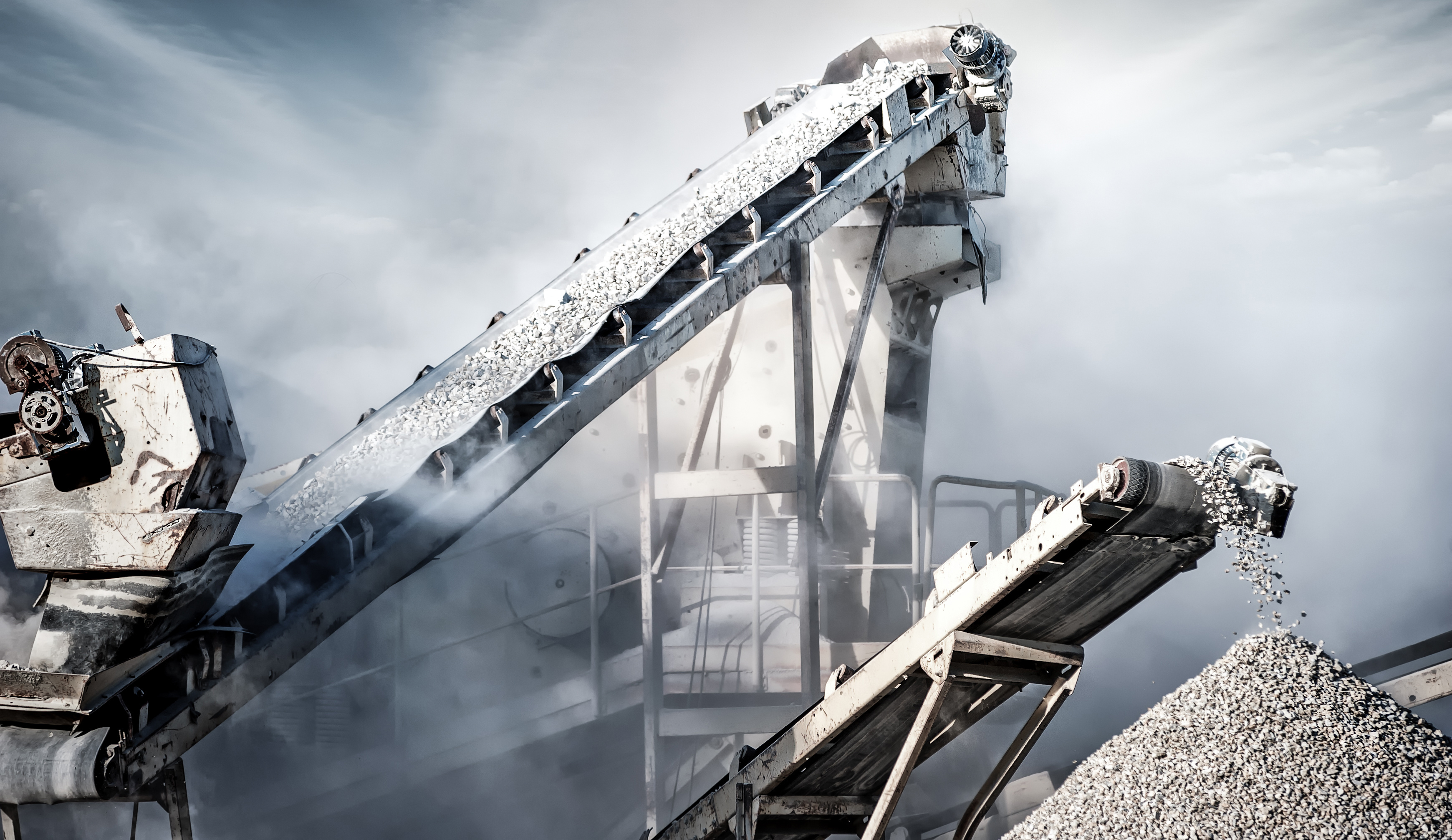 Two large mining machines sorting through rocks and debris.